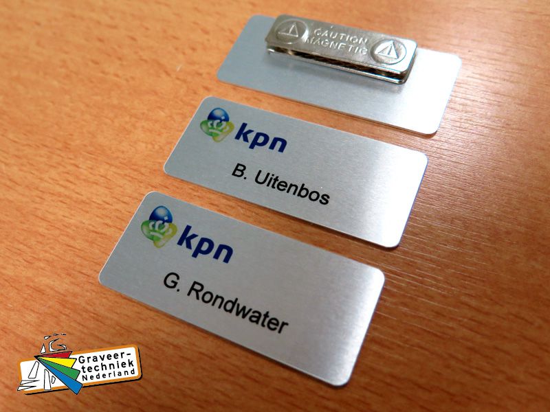 Aluminium badge, voorbeeld met een logo KPN linksboven en persoonsnaam eronder.